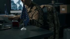 Blurred background of adult serviceman in camouflage uniform working with documents in command center of European Union - Powered by Shutterstock - Get 15% off with code: PIKWIZARD15
