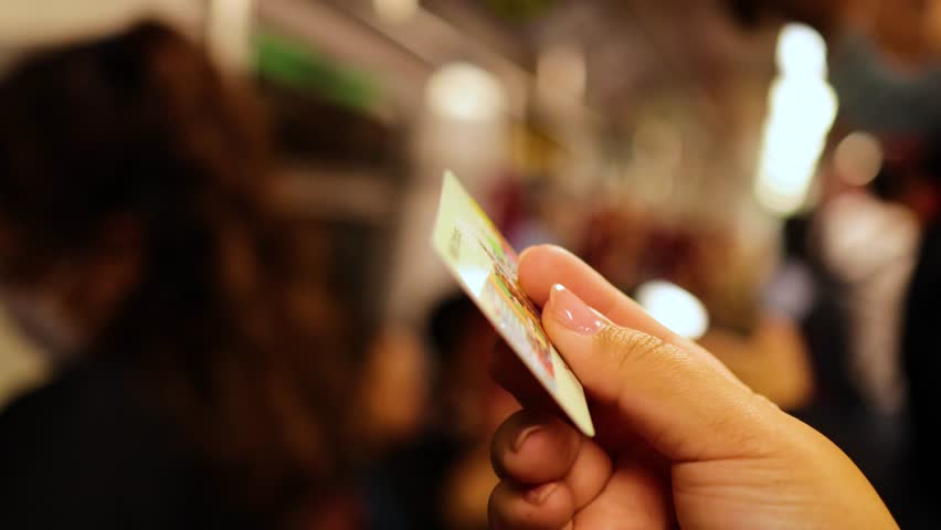 Person handling a metro card in transit