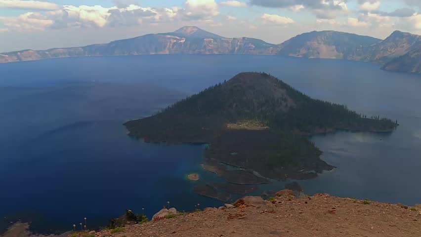 Wizard island on Crater Lake, Oregon, covered by evergreen pine forest, USA. Famous tourist viewpoint