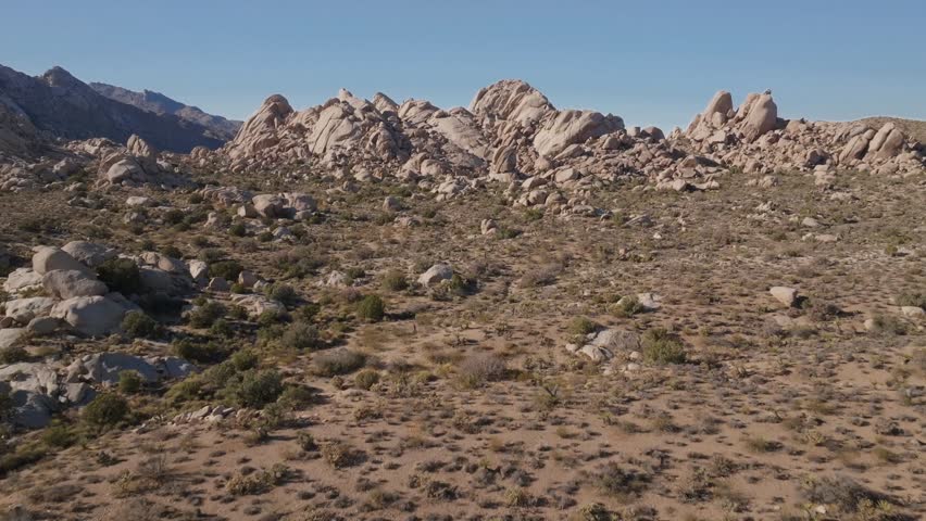 Kelso Pinto Basin Dunes Joshua Tree National Park California aerial drone Yucca Trees San Fernando County Mojave Colorado desert blue sky rugged hill rock formation sunny afternoon forward upward
