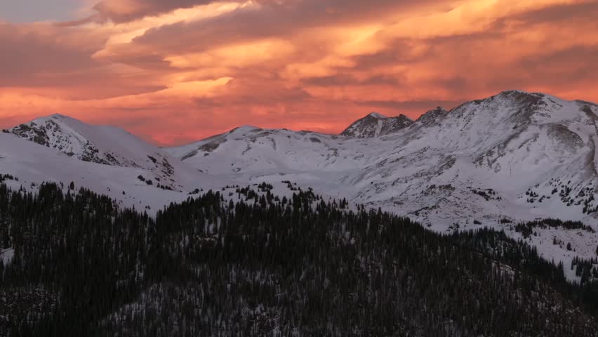Last light winter solstice December Rocky Mountains golden hour aerial drone Colorado Continental Divide Loveland Pass Herman Gulch Coon Hill vibrant sunset dusk rugged snowy peaks forward pan up