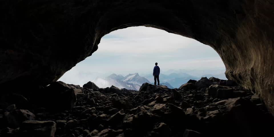 A hiker enjoys a scenic view from inside a cave on top of a mountain. Adventure, exploration, nature. 3d Rendering Cave with Image Background from BC, Canada
