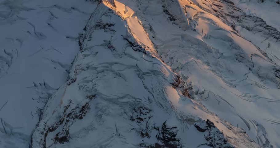 Mountain at sunrise, covered in snow and ice. Natural light and beauty. Mount Baker view from airplane, Washington, USA
