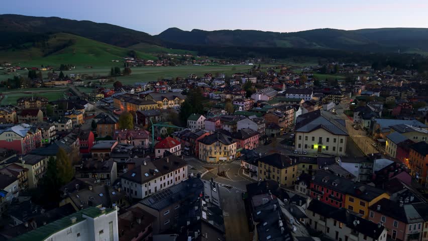 Scenic aerial view of Asiago, a charming township in the Veneto region, surrounded by rolling hills and picturesque landscapes, captured during twilight creating a serene and picturesque atmosphere.