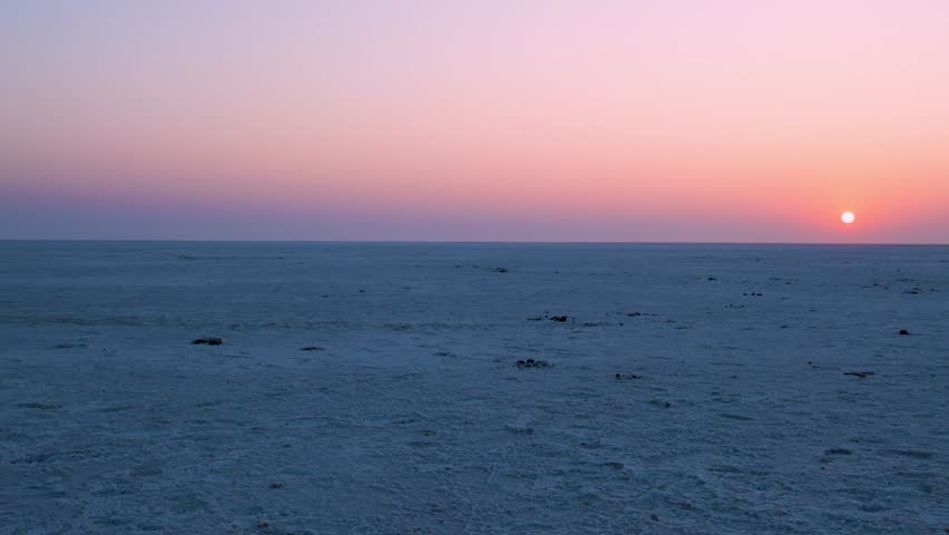 sunset horizon with white salt flats desert and dramatic orange sky at dawn video is taken at dhordo kutch white rann gujrat india.