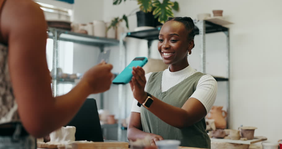 Happy woman, cashier and customer with pos machine for payment, transaction or tap to buy at ceramic store. Female person, shopper and paying with credit card or NFC for pottery shopping or purchase