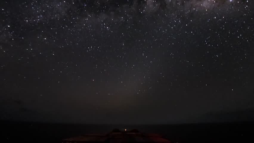 FPV or first person view of a huge or big cargo ship with container cargo boxes on board sailing and cruising through ocean sea water during days and nights with starry skies and sunshine during days.