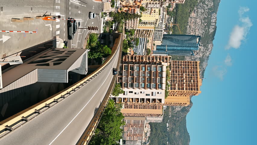 MONACO - AUGUST 21, 2021: Cityscape of the city. Road, bridge with moving cars, buildings, greenery, hills on the background