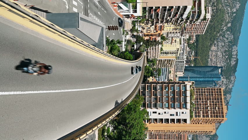 MONACO - AUGUST 21, 2021: Cityscape of the city. Road, bridge with moving cars, buildings, greenery, hills on the background