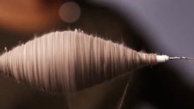 Wool fibers being skillfully twisted into yarn by a spinning spindle, showcasing the traditional process in smooth motion - Powered by Shutterstock - Get 15% off with code: PIKWIZARD15