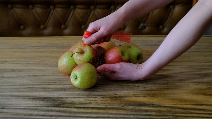 healthy food woman person in the kitchen and on the table laying out fruits apples of different varieties