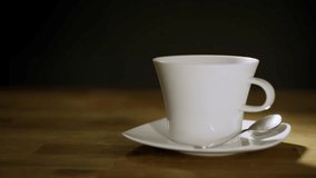 Male hand putting sugar cubes into a white coffee cup and stirring the drink with a teaspoon, close up shot. Morning enjoyment concept. - Powered by Shutterstock - Get 15% off with code: PIKWIZARD15