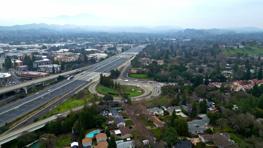 The drone captures a stunning aerial perspective of Walnut Creek, California, showcasing winding roads, neighborhoods, and surrounding hills. This serene landscape highlights urban and natural beauty.