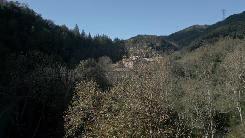 Sunlight illuminates the sant hilari sacalm thermal baths museum, nestled in a valley amidst autumnal foliage and rolling hills in girona, catalonia