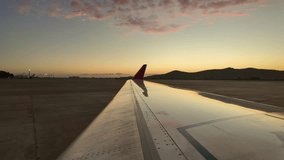 External view of the right wing of a jet with some pink ethereal clouds reflected on the wing at sunrise. Timelapse. 4K - Powered by Shutterstock - Get 15% off with code: PIKWIZARD15