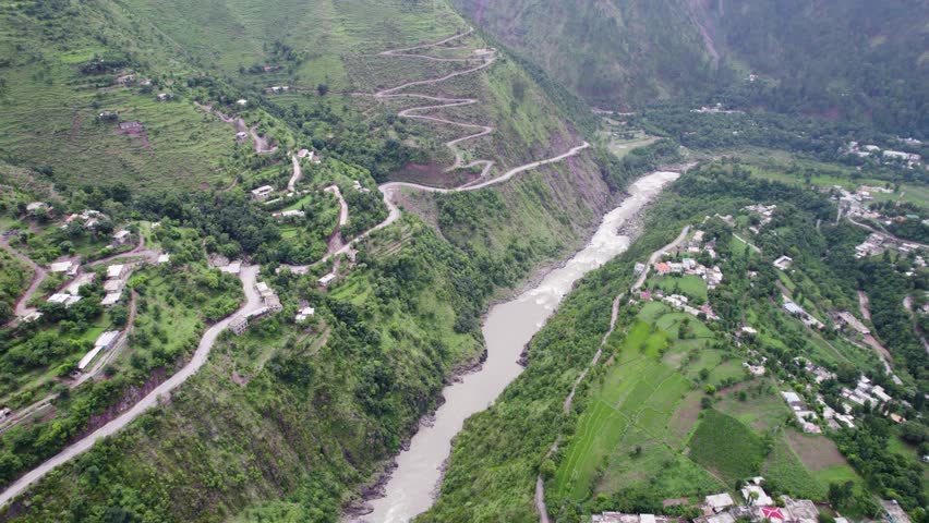 Kishan Ganga River winding road in a lush green MuzaffarAbad valley surrounded by steep mountains in Kashmir, Pakistan