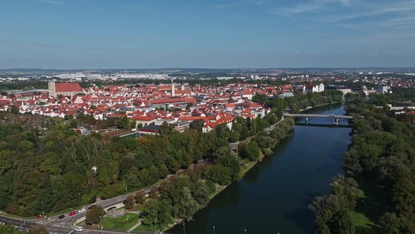Aerial drone view of the Danube River flowing through Ingolstadt, Germany, showcasing the city's scenic landscape, historic architecture, and urban charm.