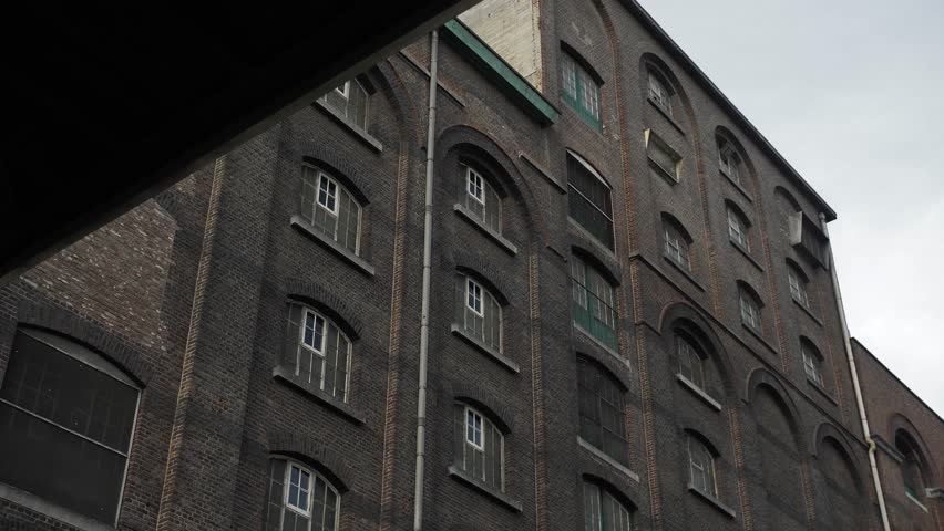 Slow motion shot uncovering the details of an aged factory building in an industrial area