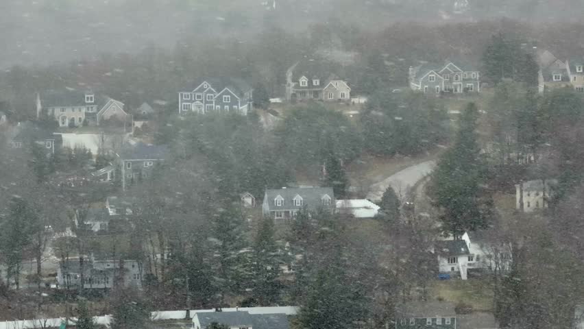 Blizzard snowstorm in american neighborhood. Aerial panning wide shot. Winter time in suburb of City. Massachusetts, USA.