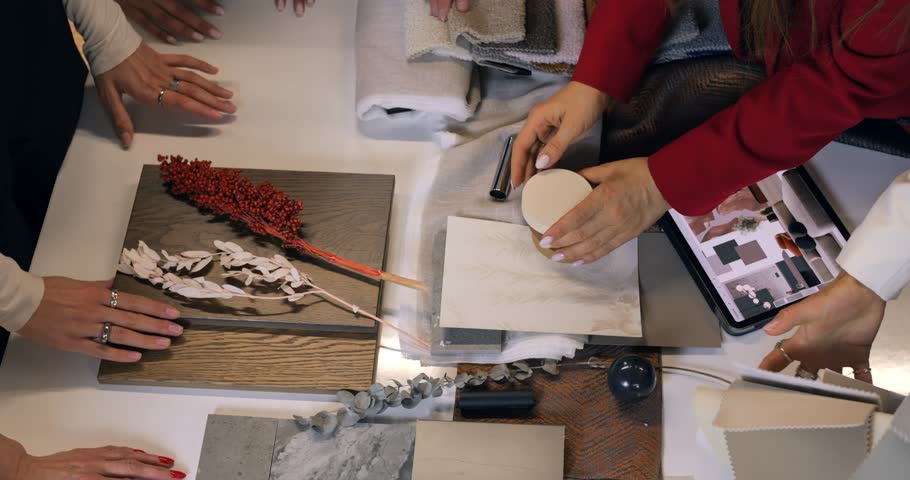 Interior designer reviewing material swatches and color palette on tablet, working on comprehensive design plan with wood, fabric, and tile samples. Concept selection of interior design. Brain Storm