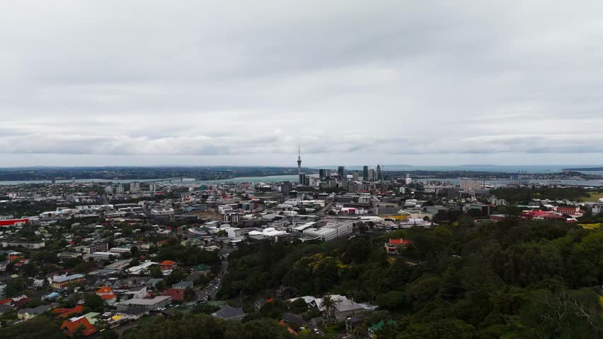 Auckland or CBD Downtown under a cloudy sky. Aerial ascent