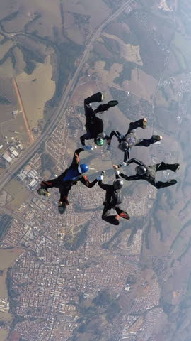 Skydiving people doing a formation in free fall. Slow motion, adventure concept.