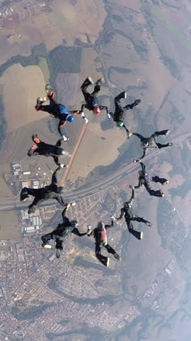 Skydiving people doing a formation in free fall. Slow motion, adventure concept.