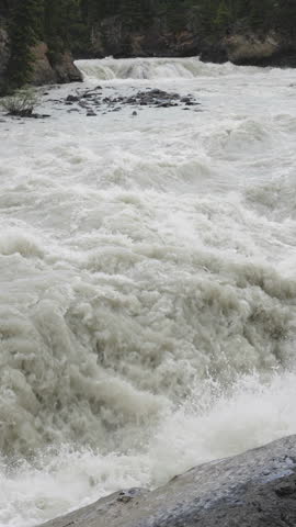 Raging whitewater rapids at Sunwapta Falls, Canada, in a dramatic outdoor scene