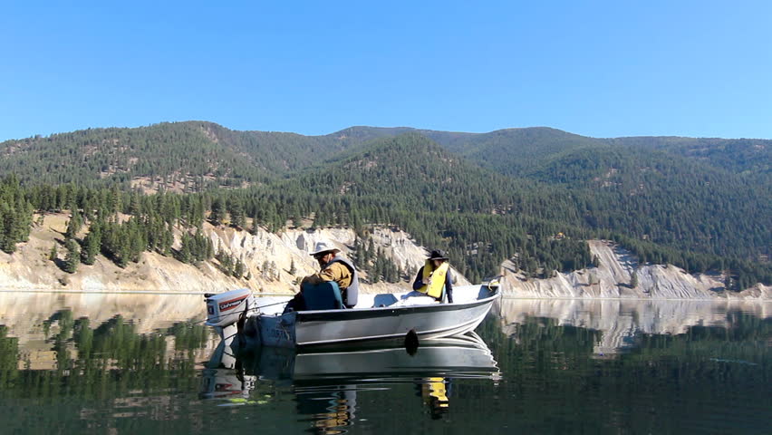 People fishing on a calm river in Montana in a small boat