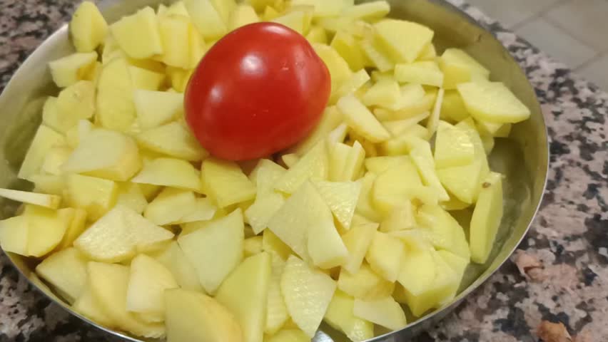 Appetizing video of freshly prepared chopped potatoes and ripe tomatoes. Perfect for culinary projects, recipe demonstrations, and healthy food content. Keywords: potatoes, tomatoes, food, cooking, he