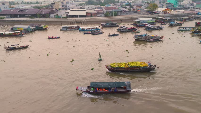 Aerial view of Cai Rang floating market, Can Tho, Vietnam. Tourists, people buy and sell food, vegetable, fruits on boat, ship at river market in Tet Holiday.