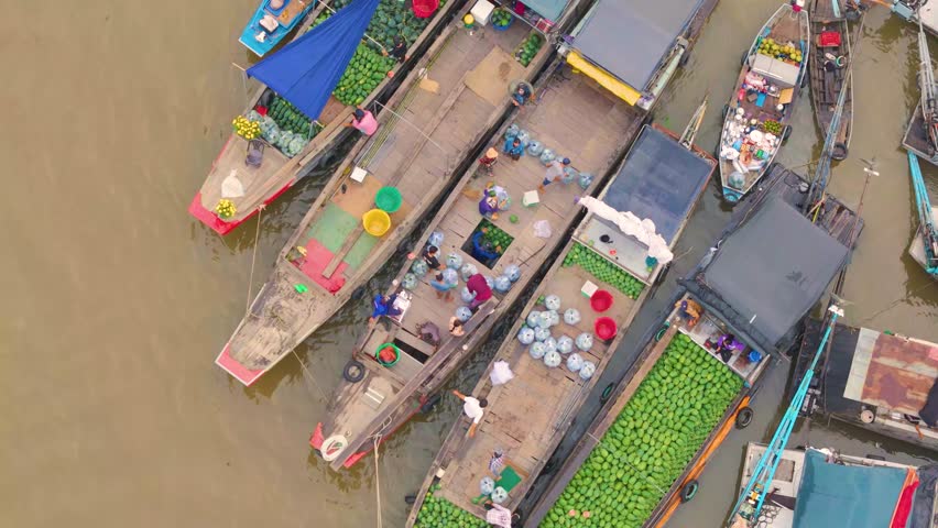 Aerial view of Cai Rang floating market, Can Tho, Vietnam. Tourists, people buy and sell food, vegetable, fruits on boat, ship at river market in Tet Holiday.