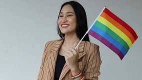 Happy smiling non-binary LGBT person waiving rainbow flag for LGBT awareness pride month - Powered by Shutterstock - Get 15% off with code: PIKWIZARD15