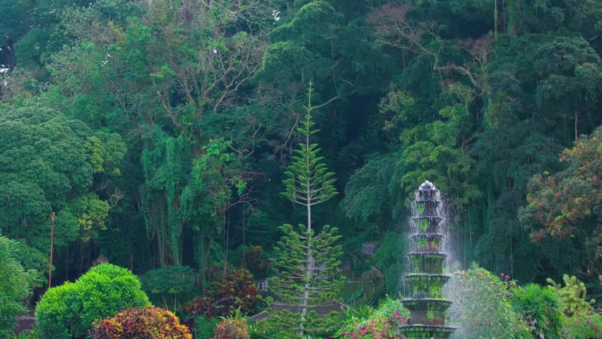 A serene garden scene featuring colorful flowers, decorative fountains, and lush greenery. The pathways are lined with vibrant plants, creating a tranquil atmosphere.