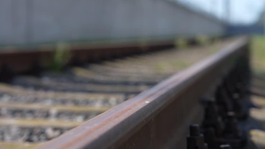 Rails, sleepers and mounting nuts close up. Railway track bolts. Detail of rusty screws and nut on railroad track. Rusty screws and nut on old railroad track. Concrete tie with rusty nuts and bolts.
