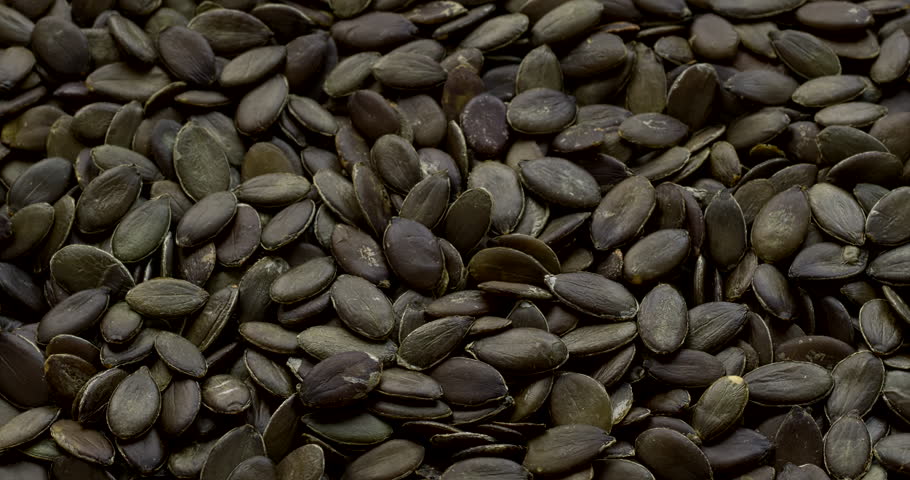 Pumpkin seeds background. Selective focus. Table spin.