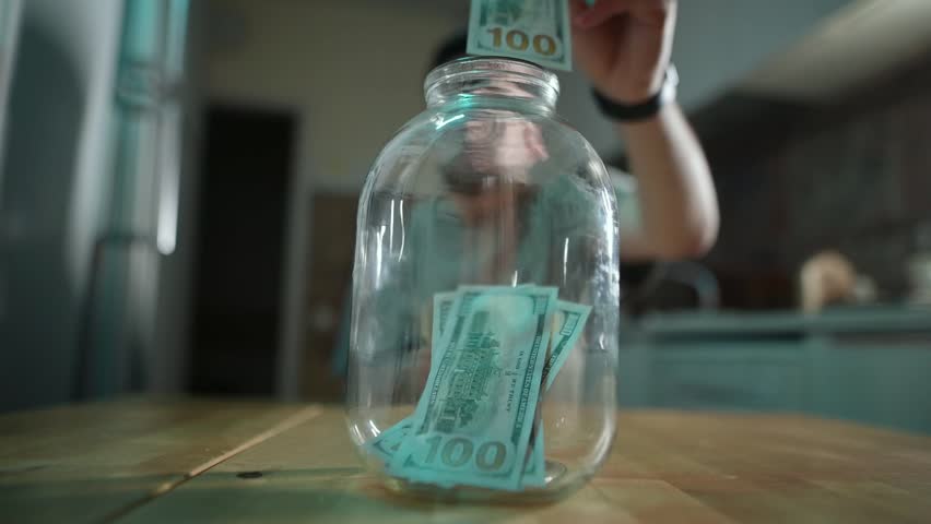 Saving money with a jar for financial goals in a kitchen setting