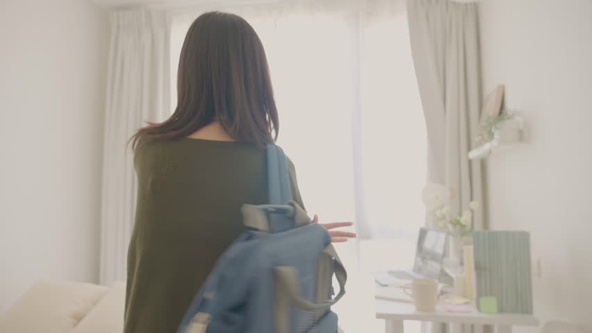 Asian young girl entering her room to study table in bedroom at home. Teenage woman come home from school, and resting on desk before doing homework in house. Back to school concept.
