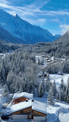 vertical video: aerial view of Chamonix in winter, French ski resort in the Alps, snowy frosty alpine landscape in Chamonix Valley, drone view of alpine village