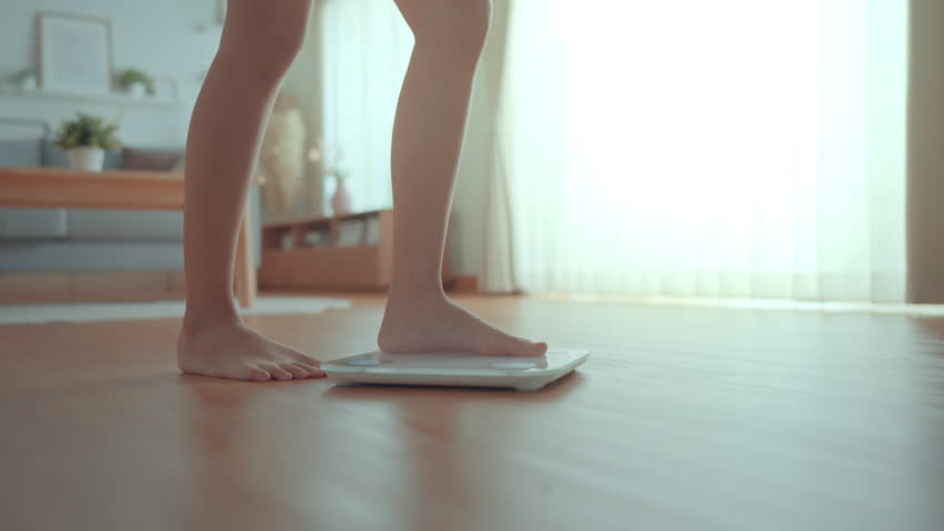 B roll - Woman Feet Standing Weighing Scales, Female Checking BMI Weight Loss. Barefoot Measuring Body Fat Overweight