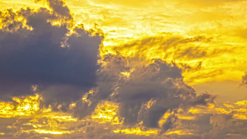 Time lapse of clouds at sunset, sunrise on a yellow colered sky, dramatic passing clouds, background