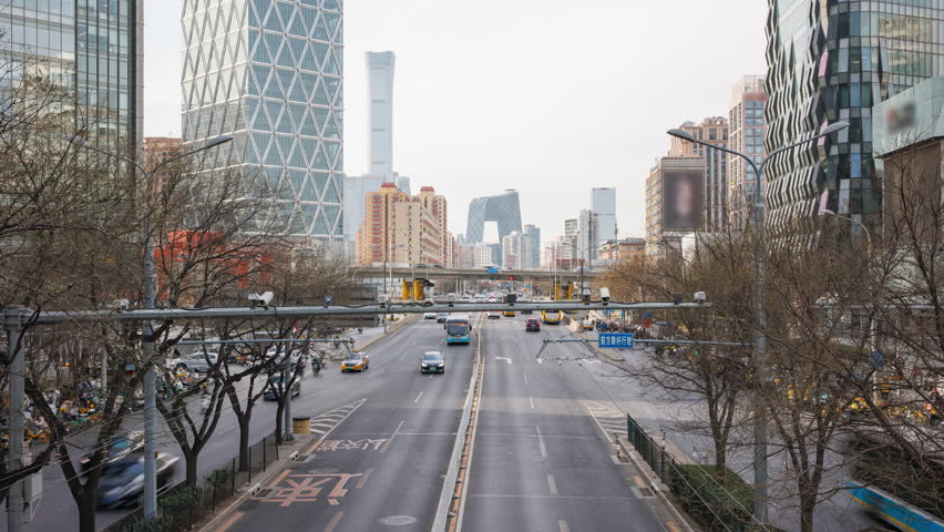 Traffic Time Lapse in the Central Business District (CBD) of Beijing, China, with iconic landmark the CCTV Headquarters building in background. Busy road filled with car commuters during rush hour. - Powered by Shutterstock - Get 15% off with code: PIKWIZARD15