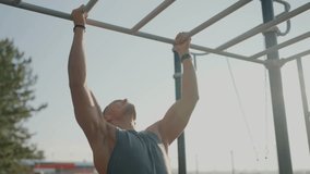A fit young man working out on monkey bars at an outdoor fitness park, showcasing determination and physical strength under a clear sky. Young Man Exercising on Monkey Bars at Outdoor Fitness Park - Powered by Shutterstock - Get 15% off with code: PIKWIZARD15