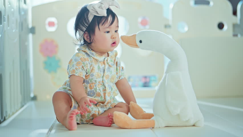 Little asian Infant baby girl 6-12 months playing with her goose doll at home, Little Toddler having fun in living room, Enhance development