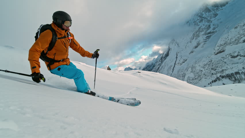Skier riding in the scenic Dolomites mountains in fresh powder snow. Super slow motion at 1000 fps.