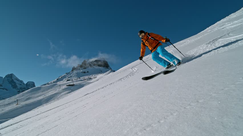 Skier riding in the scenic Dolomites mountains in fresh powder snow. Super slow motion at 1000 fps.