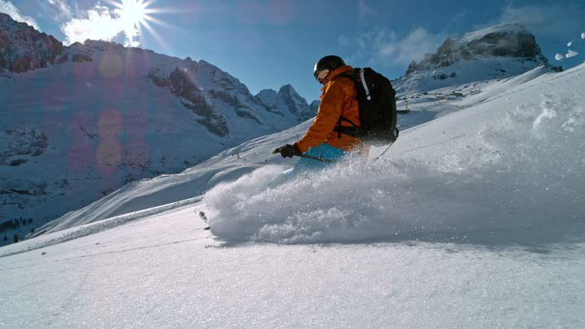 Skier riding in the scenic Dolomites mountains in fresh powder snow. Super slow motion at 1000 fps.