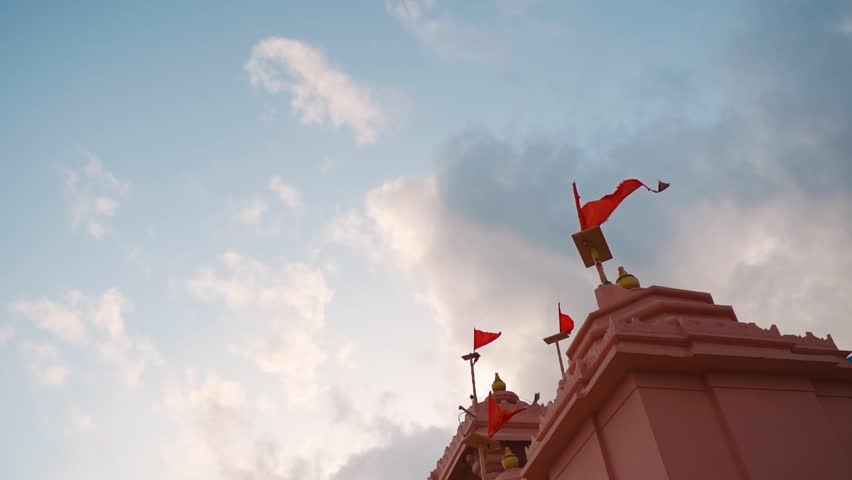 Architecture of Hindu temple and flag fluttering in wind at Kashi Vishwanath temple at Mandvi, Gujarat, India. Shiva temple in India. Faith, hope and spirituality concept. Indian culture