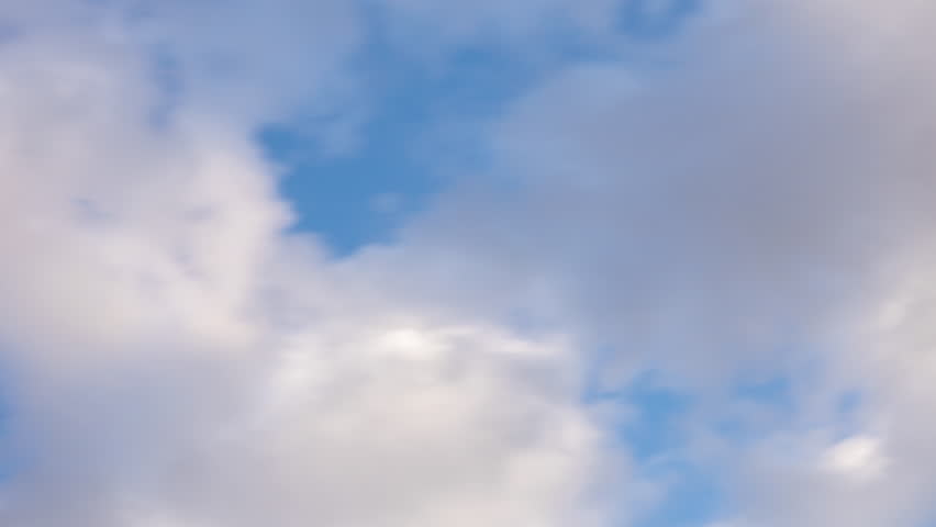 White clouds moving fast from right to left time-lapse. Daylight cloudy heaven background. Long timelapse light clouds transforming in blue sky with motion blur