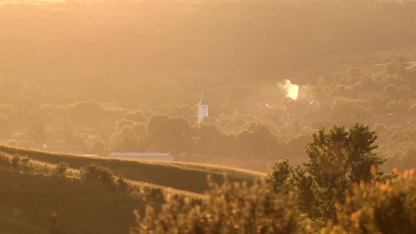 Village in Transylvania at sunset. 4k video with Taureni village from Harghita county during a beautiful summer sunset over the hills. Travel to villages of Romania.